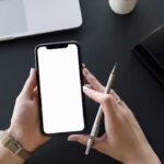 Person Holding Black Iphone and Pen